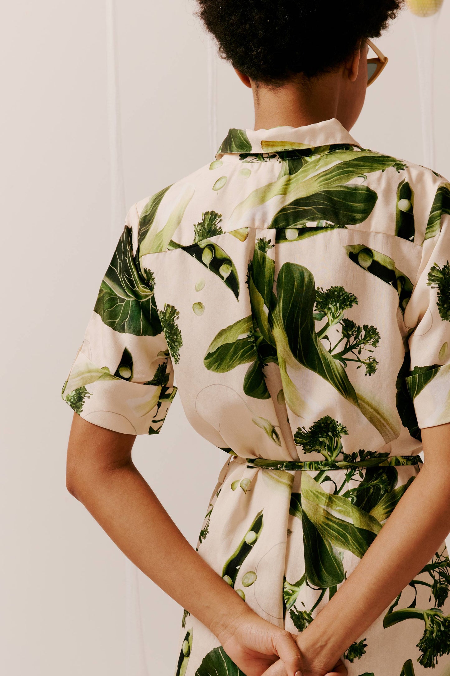 Vestido Paris Um Pouco de Salada bege, estampa de vegetais verdes (brócolis, folhas, ervilhas). Estilo camisa, mangas curtas.