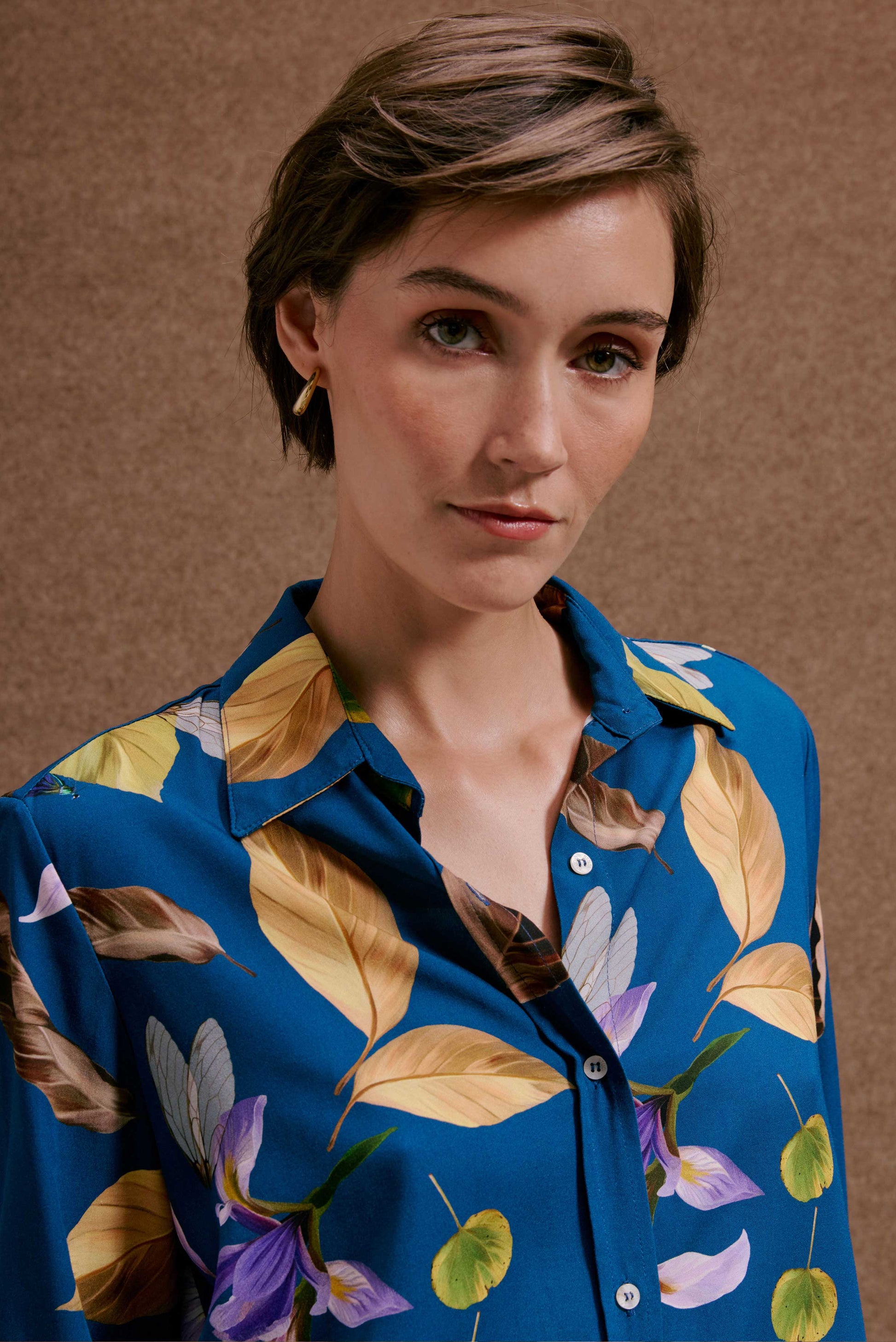 Camisa ML Anoitecer Botânica: azul vibrante com estampa de folhas douradas, marrons, flores roxas e borboletas. Sofisticada.
