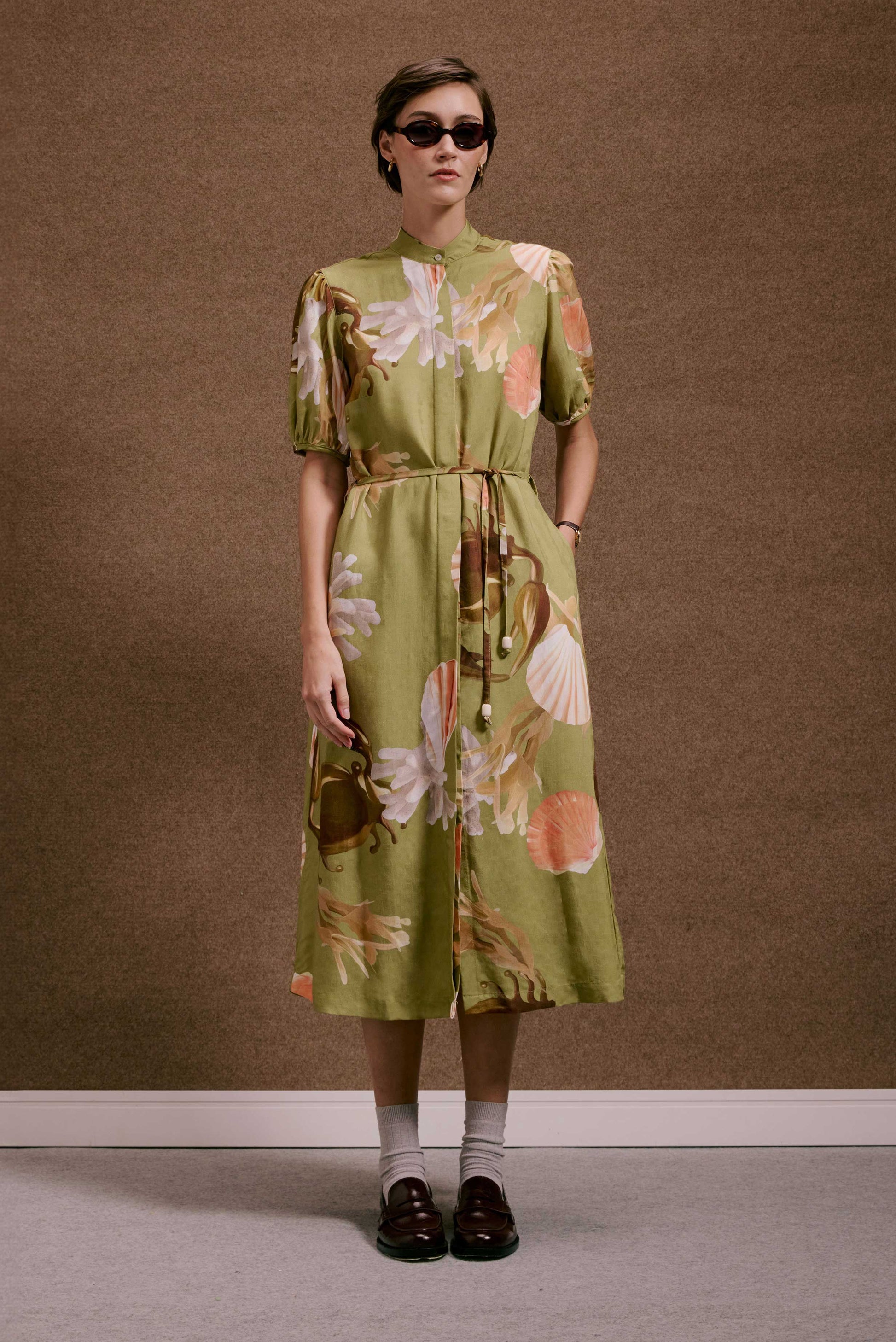 Vestido Roma Lembranças Verde midi de tecido texturizado, com estampa de conchas e algas, manga bufante, cinto e gola.