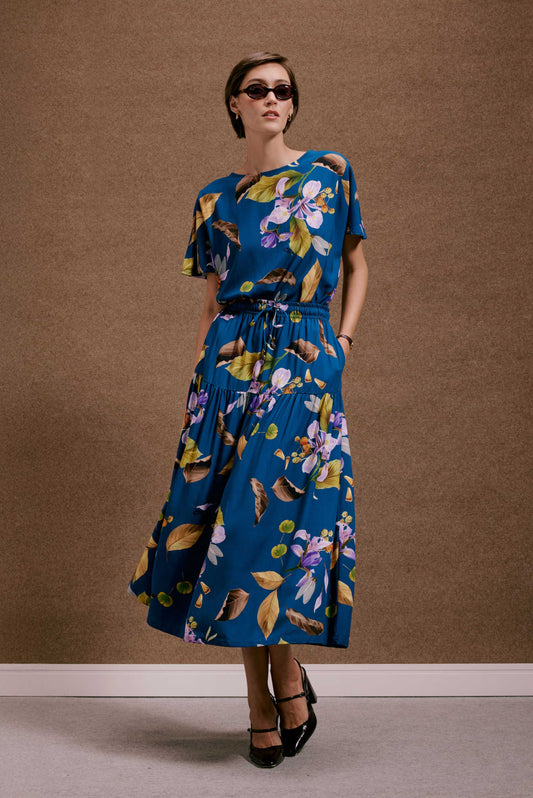 Vestido azul midi com estampa botânica 'Saia Gipsy Anoitecer Botânica'. Modelo fluido de mangas curtas e cintura elástica.