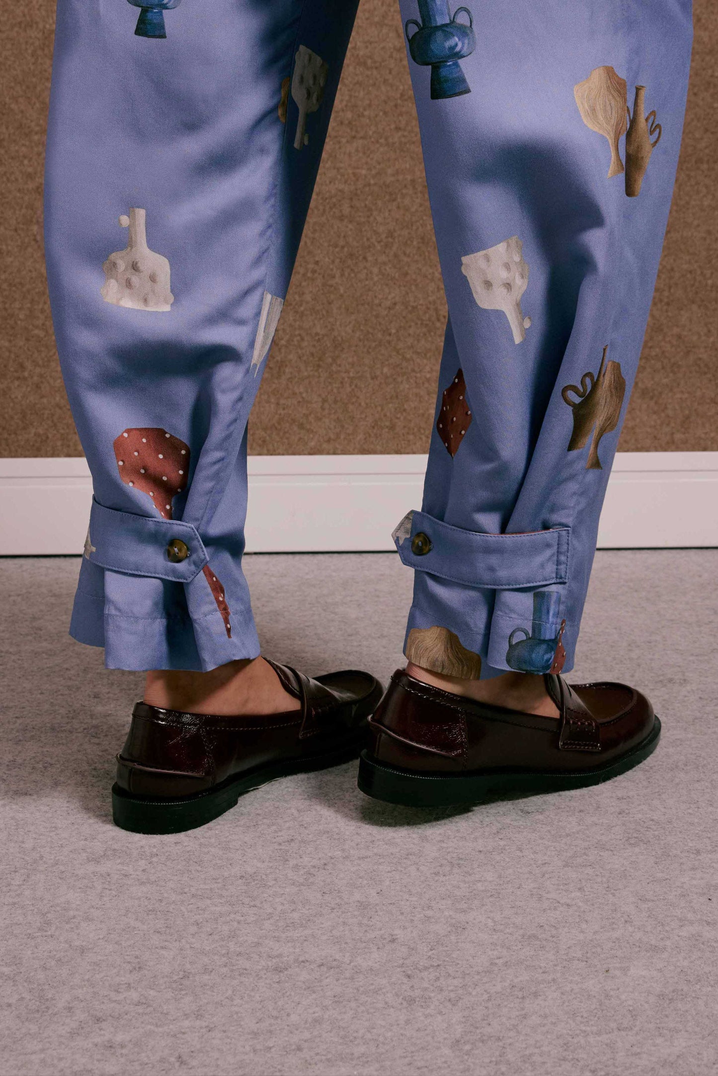 Calça Porto Vasinhos Mini azul lavanda, estampa vasos coloridos, barra com botão, sapatos mocassim.
