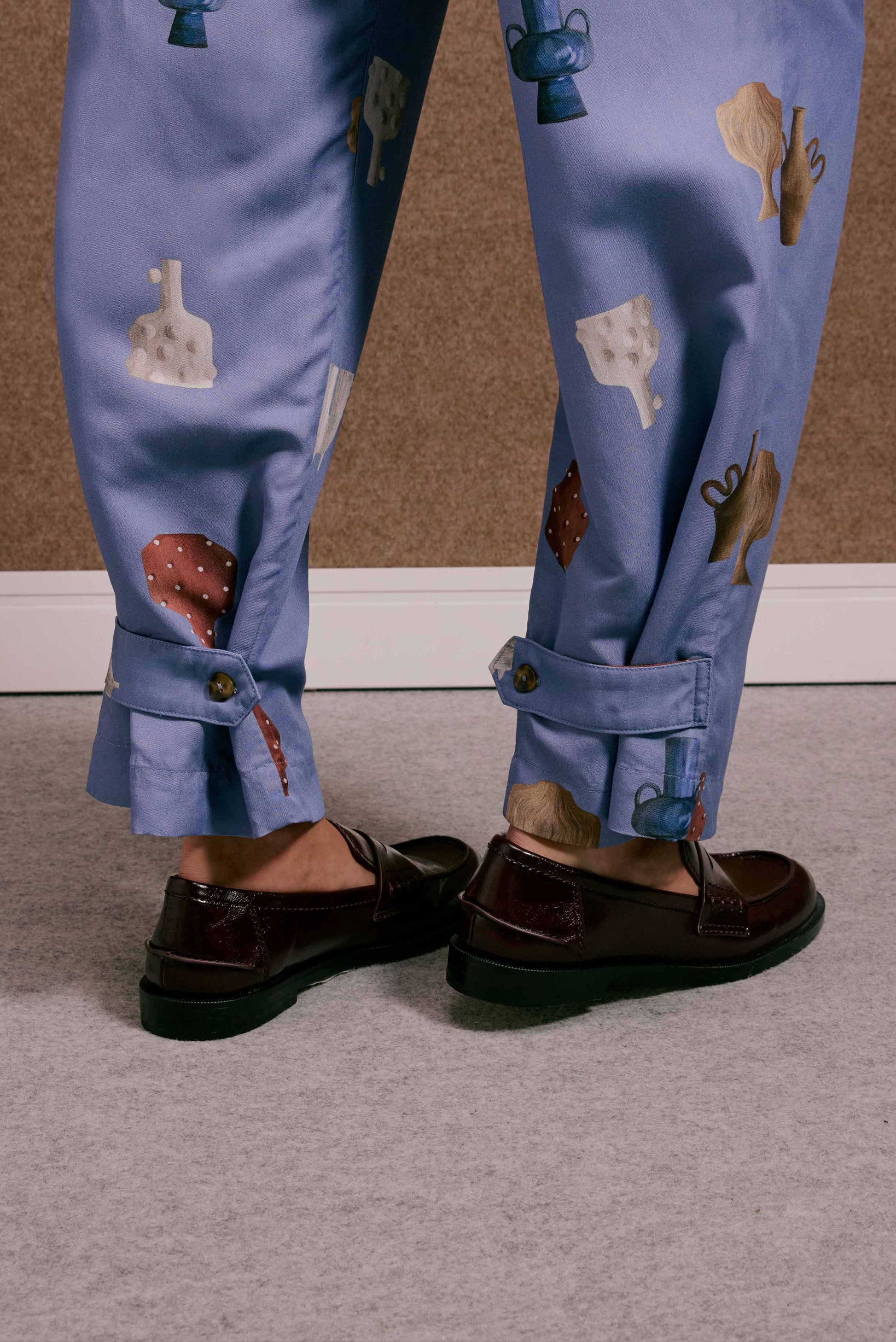 Calça Porto Vasinhos Mini azul lavanda, estampa vasos coloridos, barra com botão, sapatos mocassim.