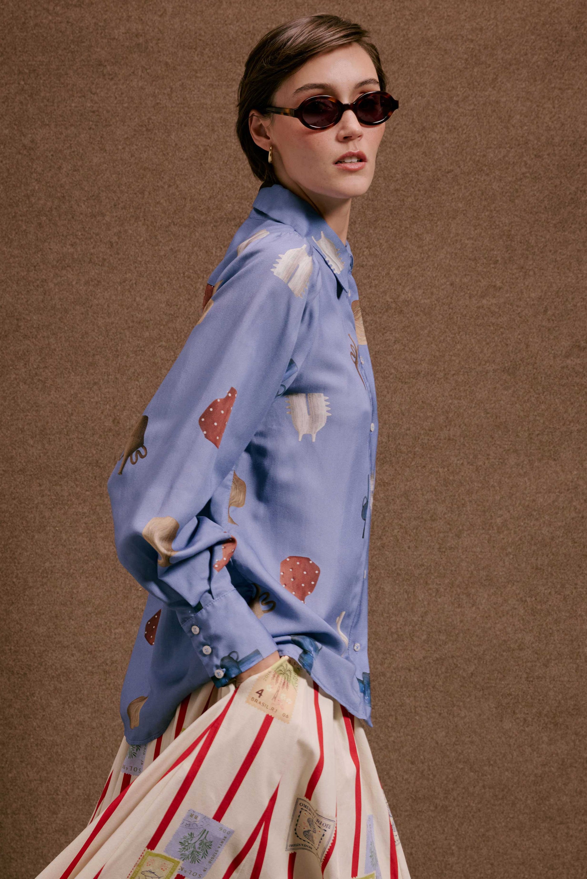 Camisa Studio Vasinhos Mini azul clara sedosa, manga longa, estampa de vasinhos terrosos e vermelhos, em mulher.