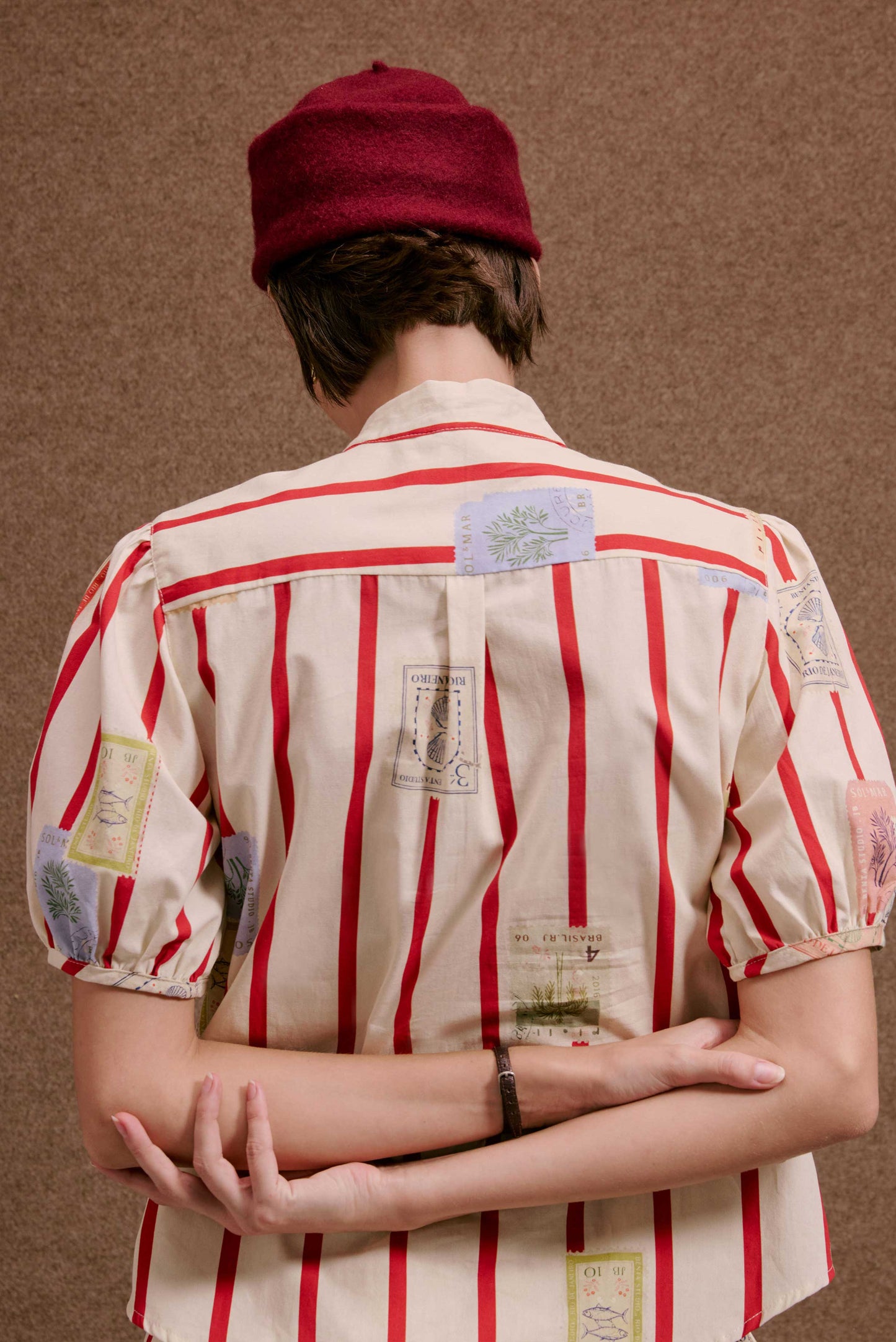 Blusa Roma Selos Listras, creme com listras vermelhas e estampas de selos coloridos de peixes, plantas e conchas, vista de...