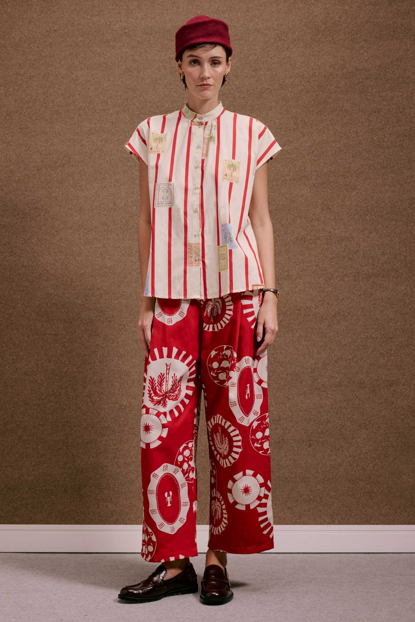Mulher veste Camisa Gênova Selos Listras creme/vermelha com selos, calça vermelha ampla com padrões circulares, chapéu e m...
