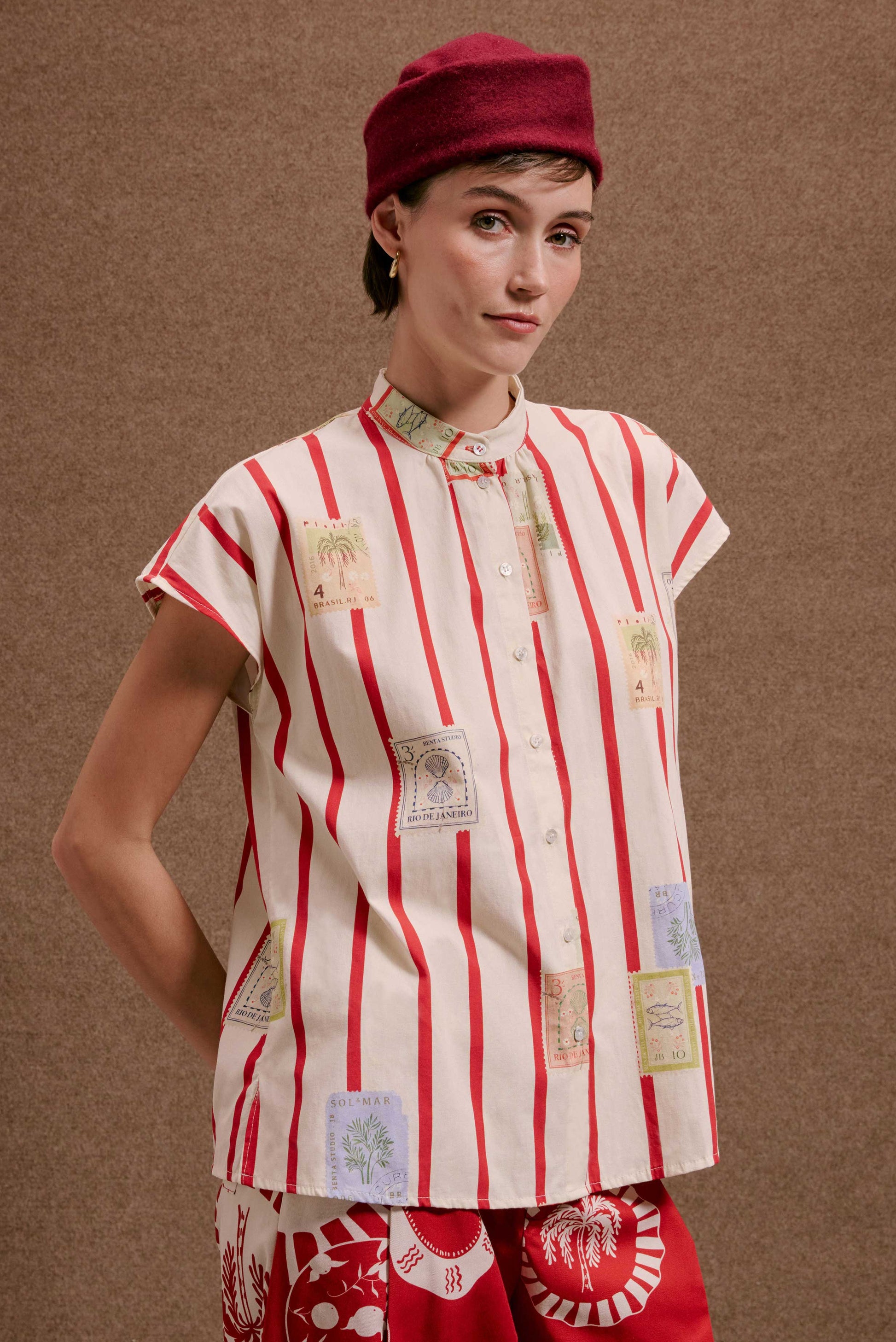 Camisa Gênova Selos Listras feminina, branca c/ listras vermelhas e estampas de selos postais do Brasil, manga curta.