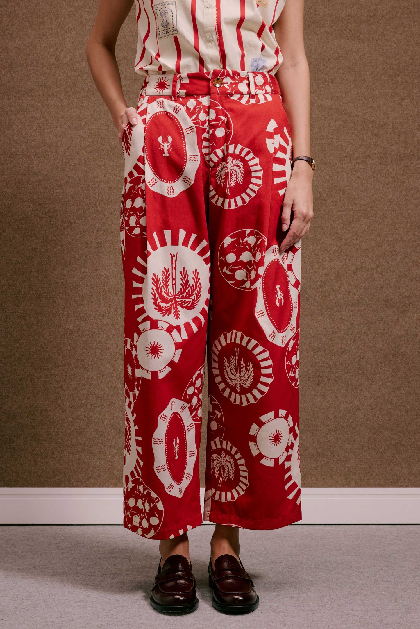 Calça Japão Pratinhos Vermelho, cintura alta, com estampa viva em vermelho e off-white de pratos com lagosta, sol e coqueiro.
