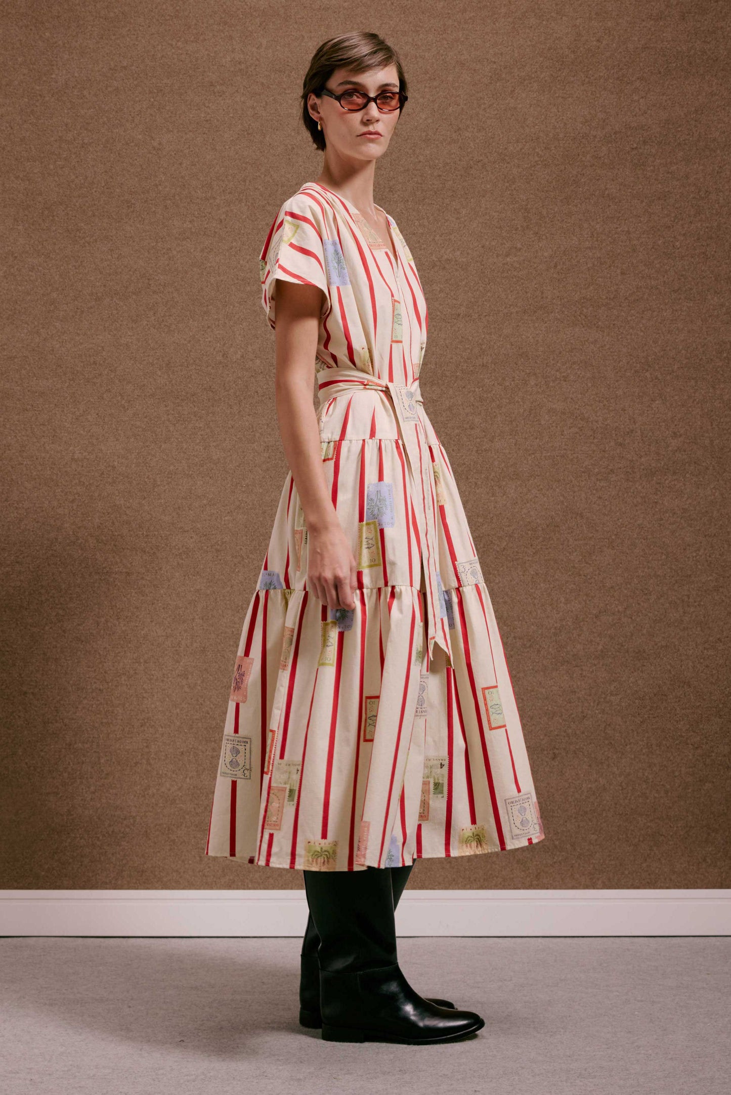 Vestido Galeria Selos Listras: midi creme com listras vermelhas, estampa de selos. Decote V, cinto, saia em camadas.