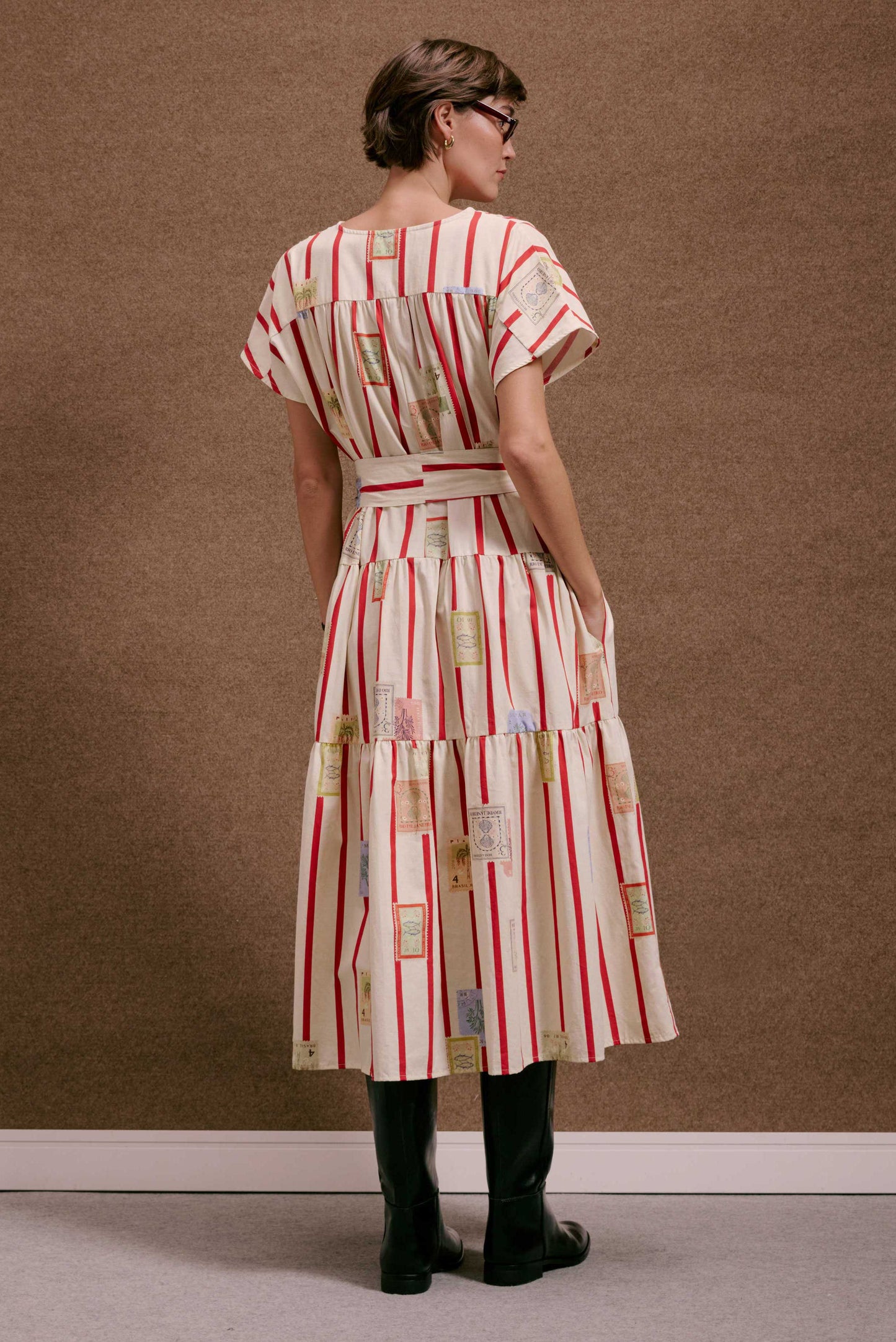 Vestido Galeria Selos Listras: midi, branco com listras vermelhas verticais e estampas de selos. Manga curta, cintura com ...