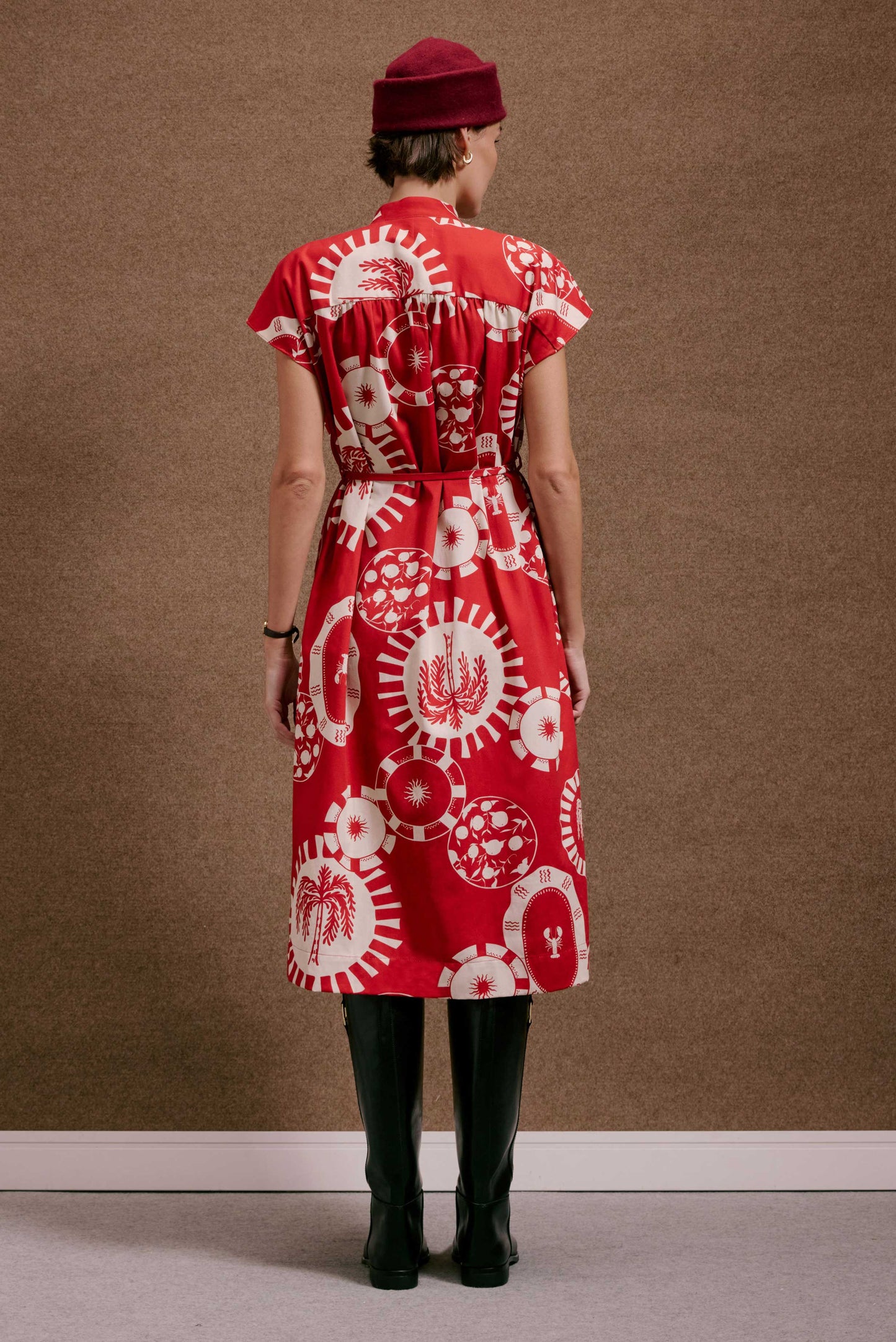 Vestido Gênova Pratinhos Vermelho: midi, estampado em branco com motivos circulares, sol, palmeira e lagosta, manga curta.