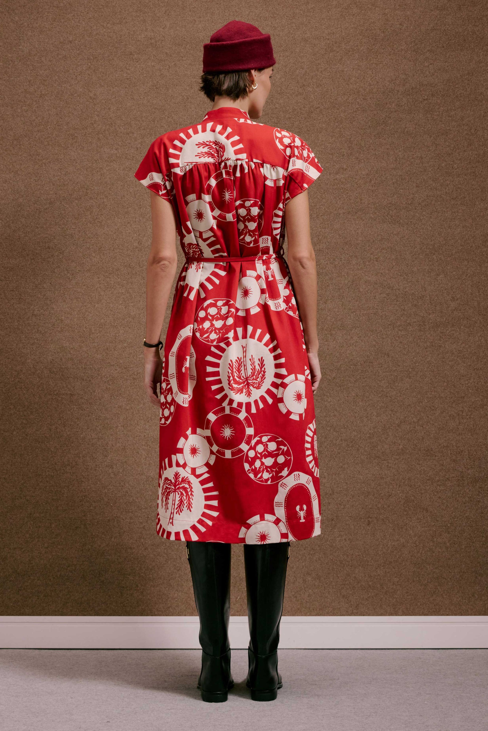 Vestido Gênova Pratinhos Vermelho: midi, estampado em branco com motivos circulares, sol, palmeira e lagosta, manga curta.
