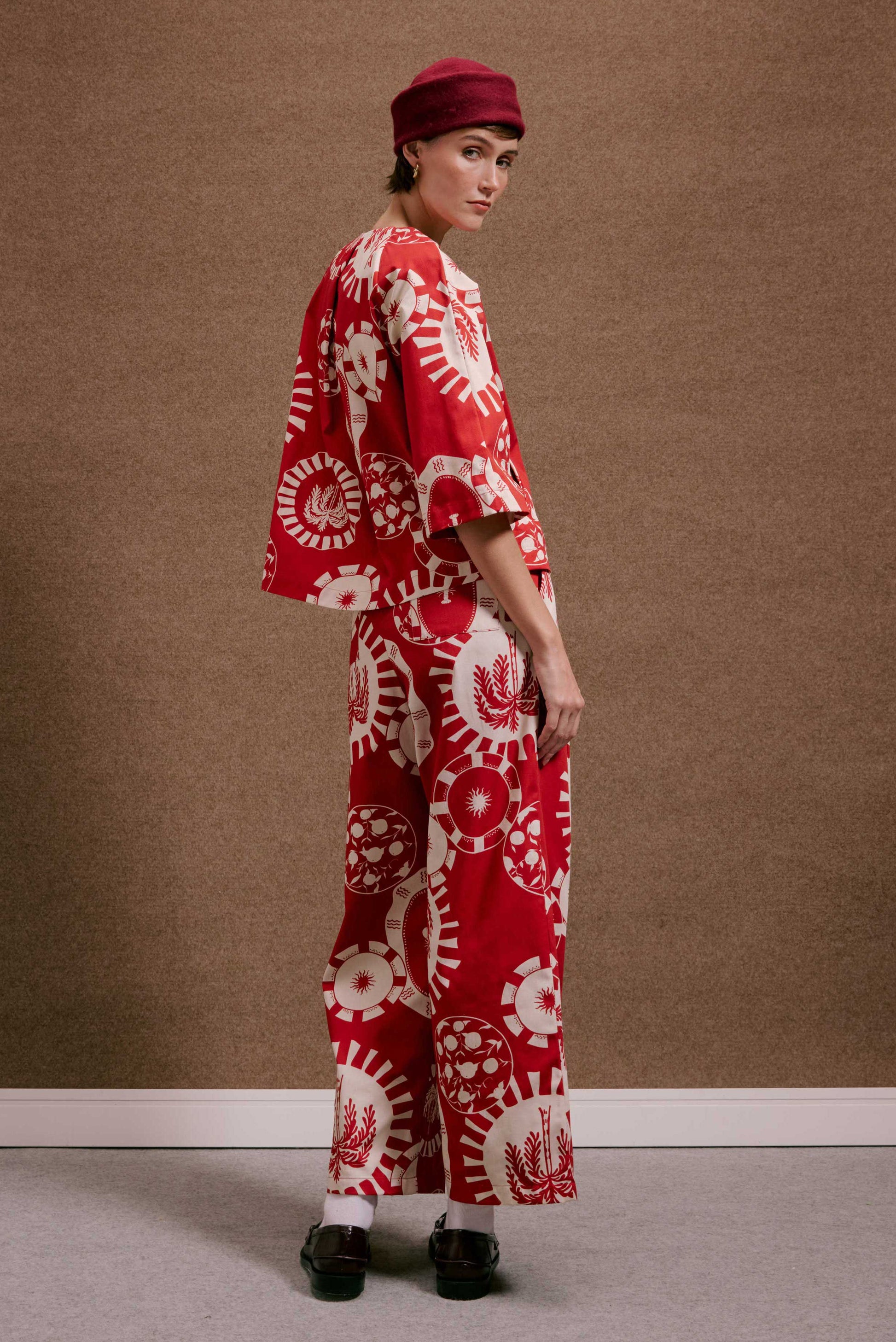 Blusa/Casaco Diário Pratinhos Vermelho: conjunto estampado vermelho e creme, com sóis e folhas em círculos.