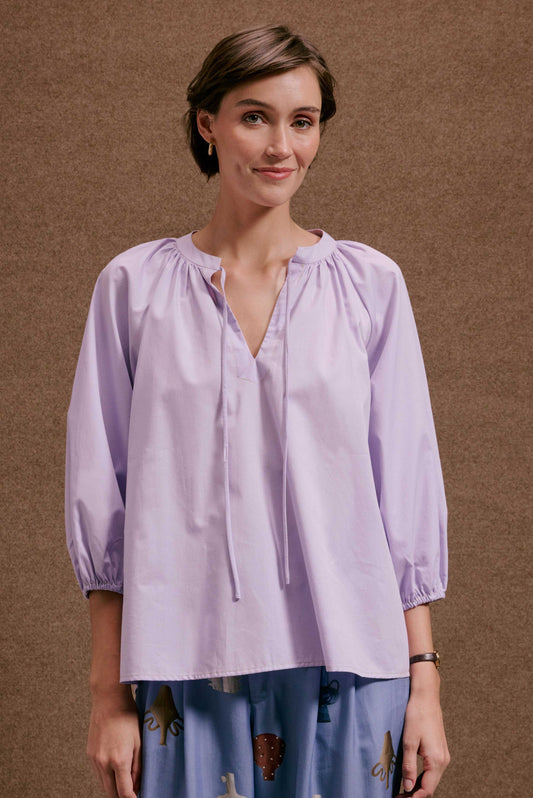 Blusa Boho Orquidário lilás de algodão, decote V com amarrações frontais e mangas 3/4 bufantes com punho elástico.