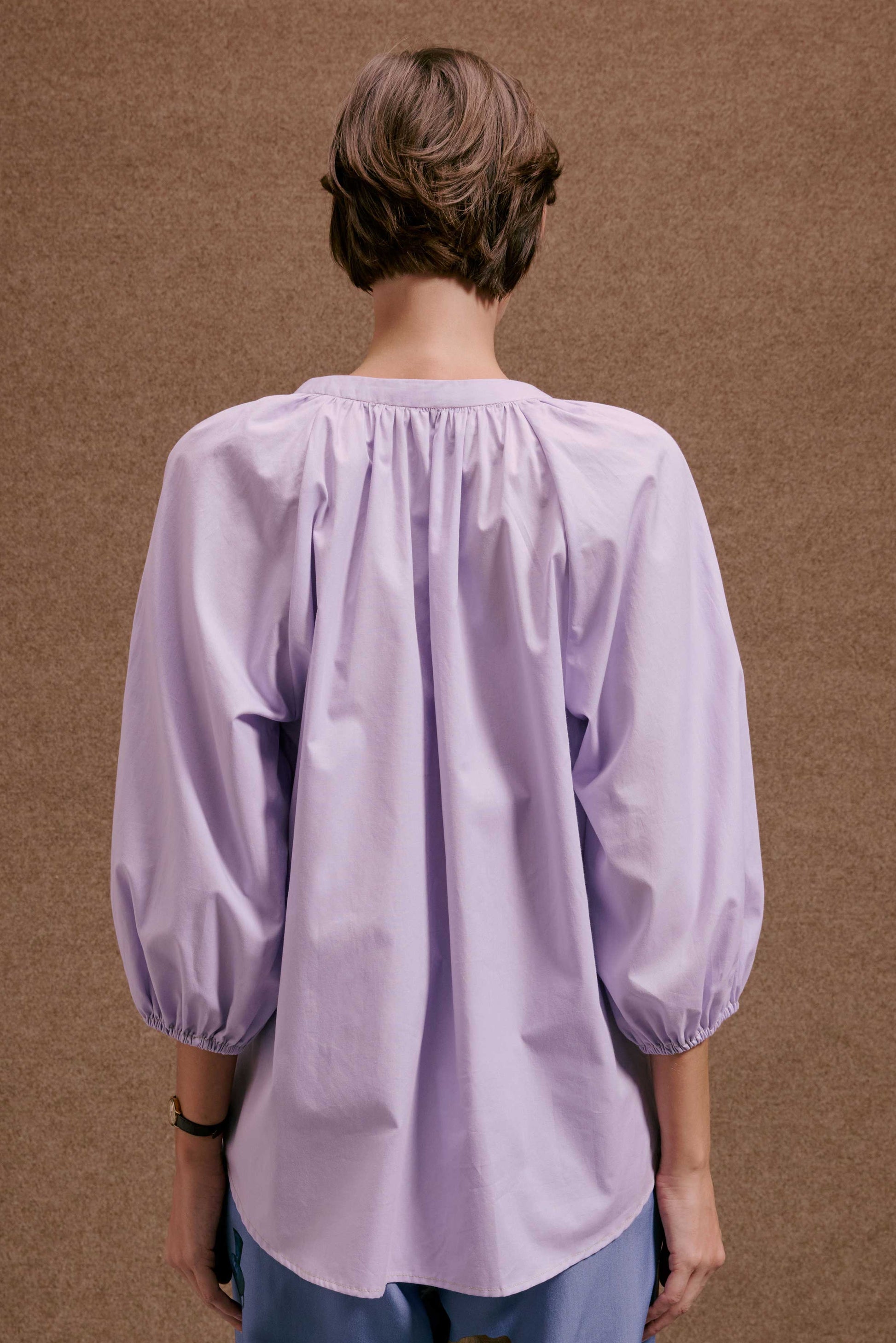Blusa Boho Orquidário lilás, vista por trás, mangas 3/4 bufantes e decote franzido.